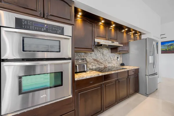 a kitchen with stainless steel appliances granite countertop a stove microwave and refrigerator