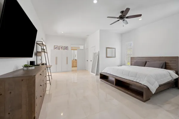 a spacious bedroom with a bed and a flat screen tv