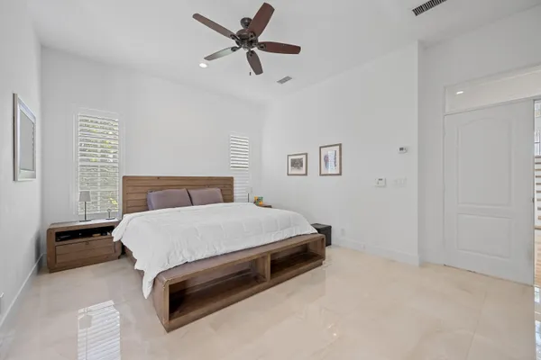 a bedroom with a bed and a ceiling fan