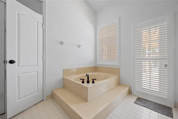 a white bath tub sitting in a bathroom next to a window