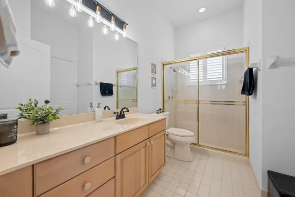 a bathroom with a double vanity sink toilet and shower