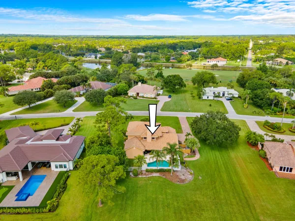 an aerial view of residential houses with outdoor space and lake view