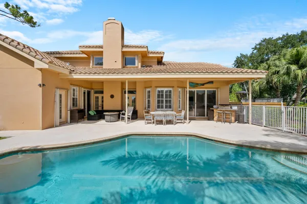 a house view with swimming pool outdoor seating and garden