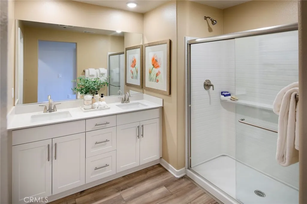 9521 Hannah Way Riverside, CA 92505 - Photo 15 of 20 a bathroom with a double vanity sink a mirror a shower and vanity