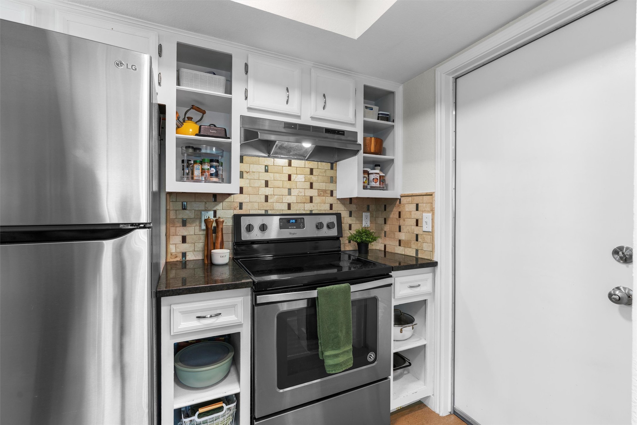 3431 Bliss Spillar Road Manchaca, TX 78652 - Photo 11 of 30 Kitchen with open shelves, stainless steel appliances, white cabinetry, and tasteful backsplash