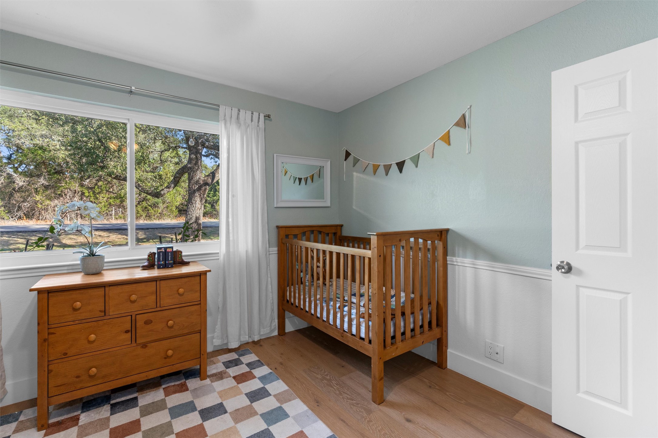 3431 Bliss Spillar Road Manchaca, TX 78652 - Photo 20 of 30 Bedroom with a crib and light wood finished floors