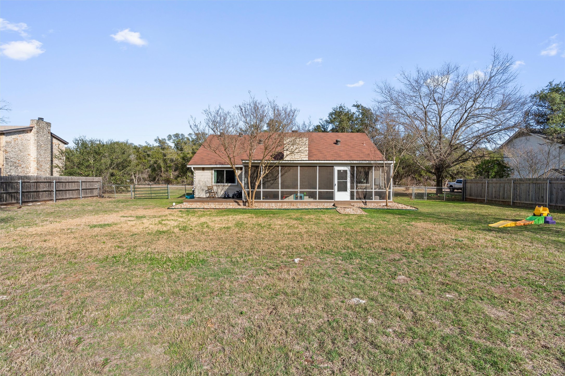 3431 Bliss Spillar Road Manchaca, TX 78652 - Photo 26 of 30 Back of property featuring a sunroom and a fenced backyard