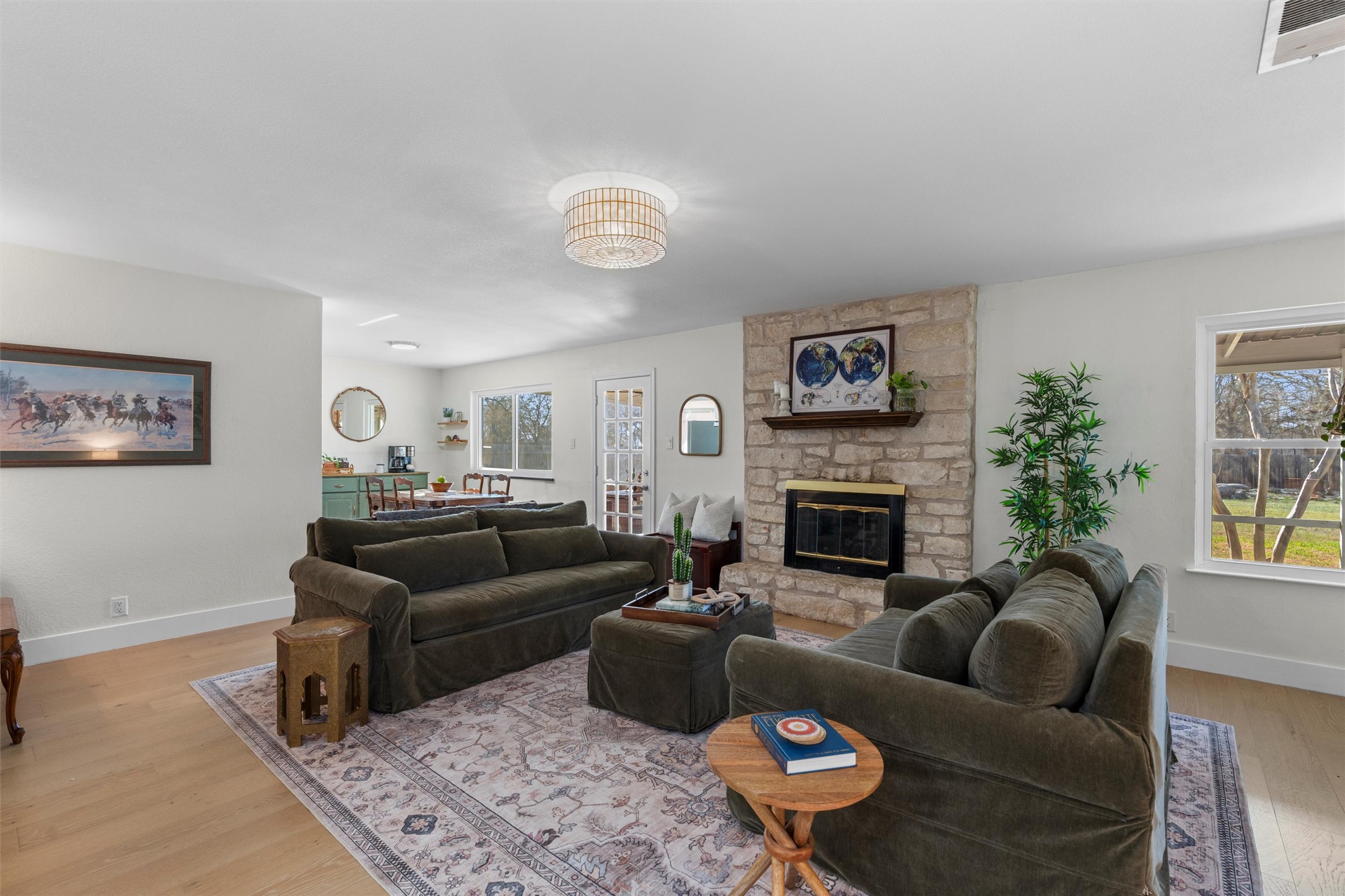 3431 Bliss Spillar Road Manchaca, TX 78652 - Photo 3 of 30 Living room with light wood-style floors and a stone fireplace