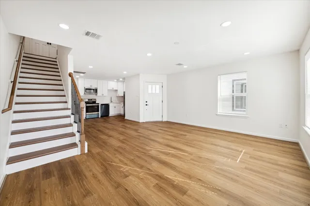 a view of empty room with wooden floor