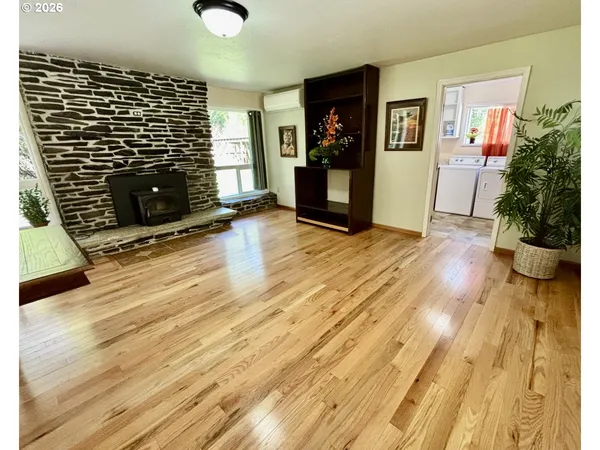 a view of empty room with wooden floor and fireplace