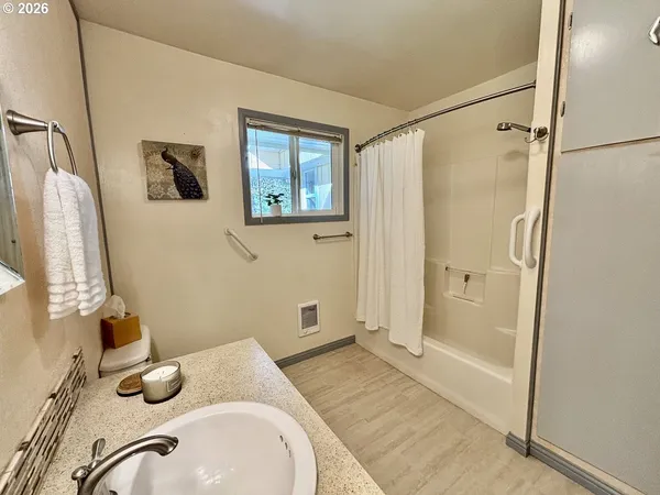 a bathroom with a granite countertop sink toilet and shower