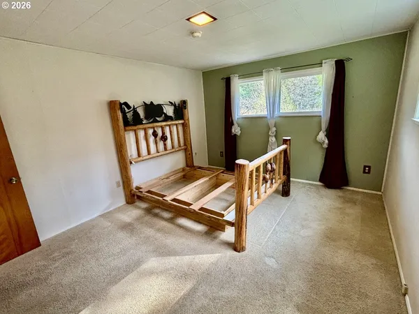 a bed sitting in a bedroom next to a window