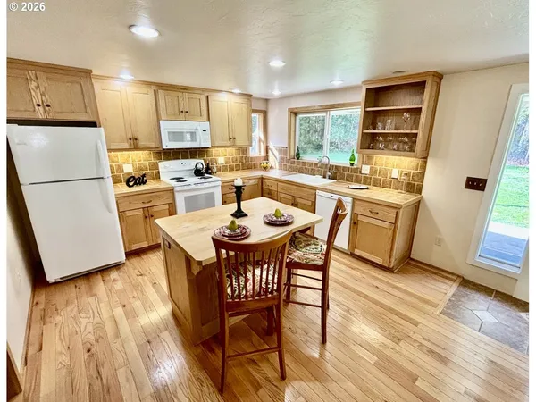a kitchen with a table chairs refrigerator and microwave