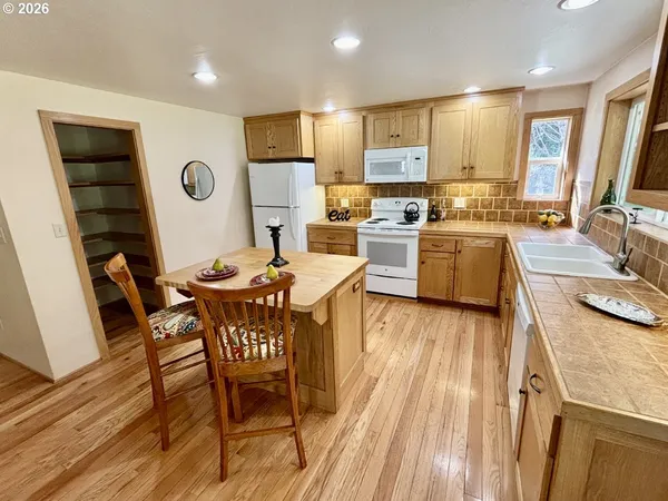 a kitchen with a table chairs refrigerator and microwave