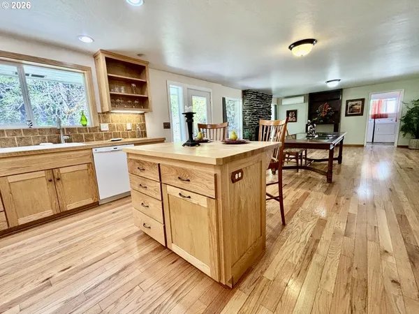 a kitchen with stainless steel appliances granite countertop a stove a sink dishwasher and a microwave oven with wooden floor
