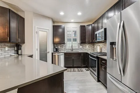 a kitchen with stainless steel appliances granite countertop a refrigerator stove and sink