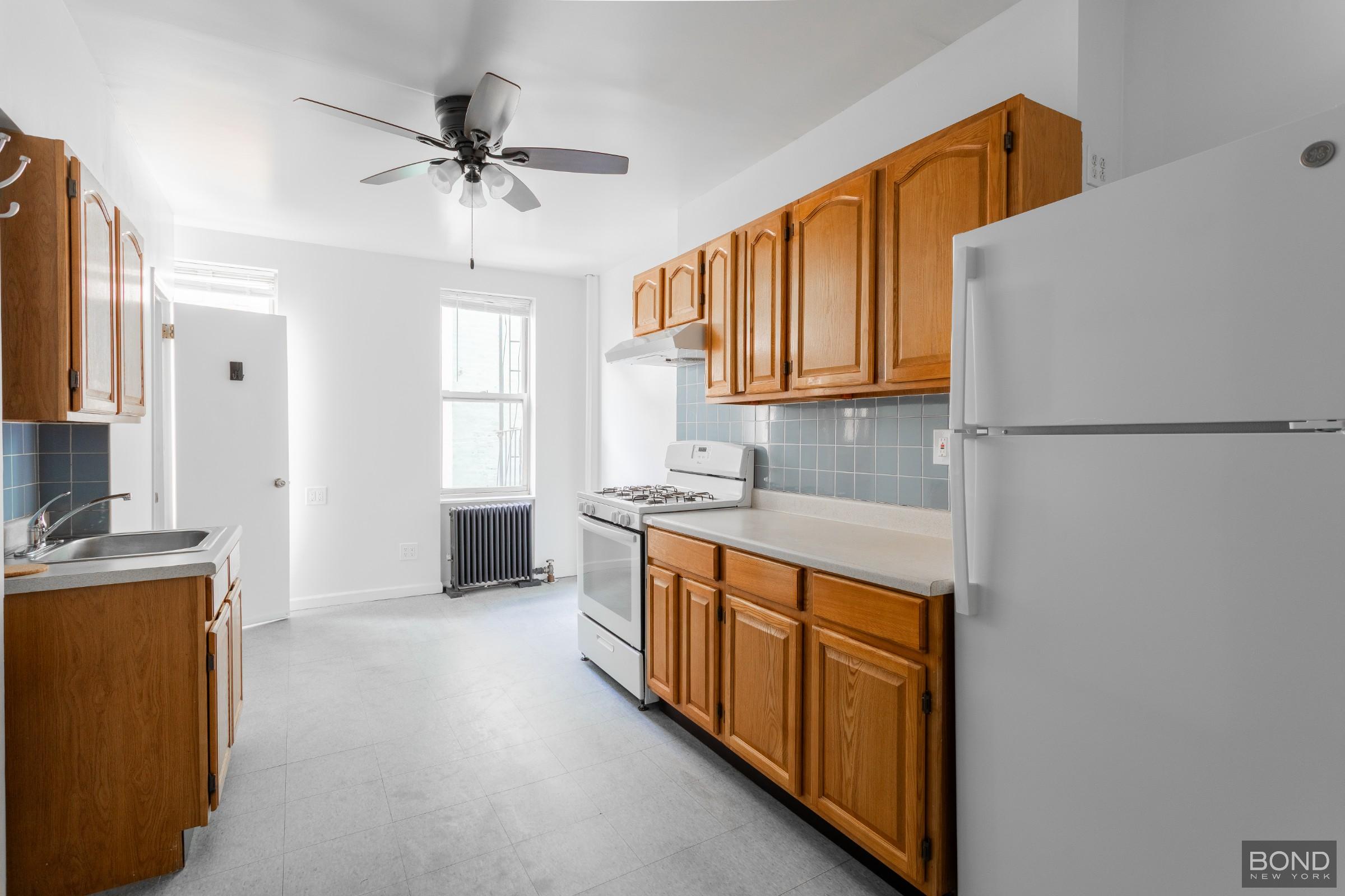 a kitchen with stainless steel appliances granite countertop a refrigerator a sink dishwasher a stove with white cabinets and wooden floor