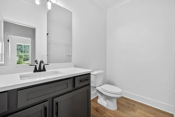 a bathroom with a granite countertop toilet a sink and a mirror