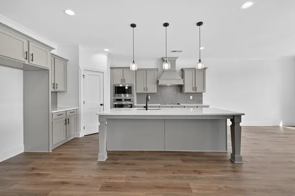 a view of kitchen with stainless steel appliances granite countertop cabinets and wooden floor