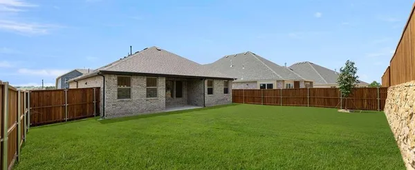 a house that is sitting in the grass with wooden fence