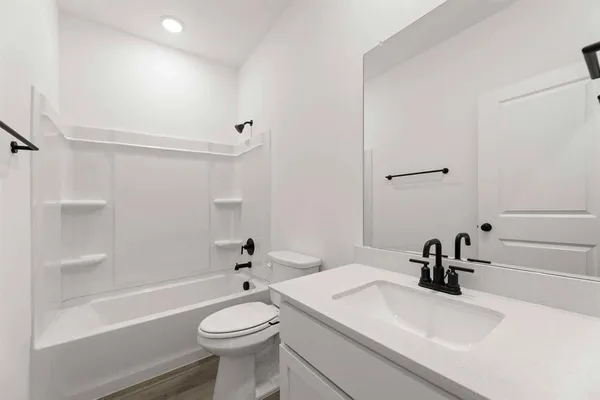 a bathroom with a sink a toilet and a mirror