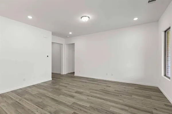a view of an empty room with wooden floor