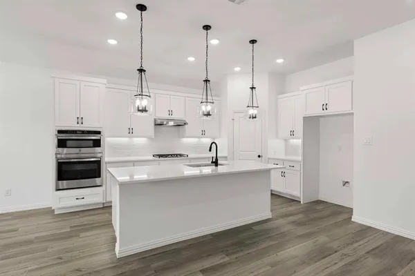 a kitchen with stainless steel appliances kitchen island a refrigerator and a sink