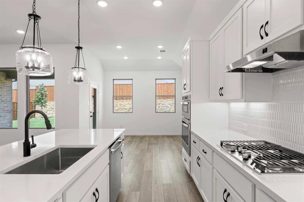1909 Wishon Road Celina, TX 75009 - Photo 30 of 40 a kitchen with granite countertop a stove a sink a refrigerator and a wooden floor