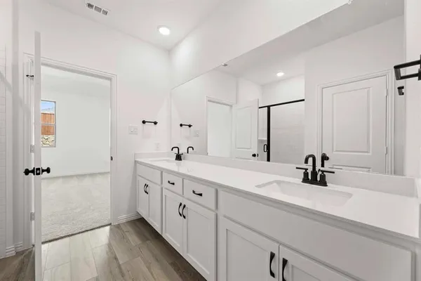 a bathroom with double vanity sink a mirror and shower