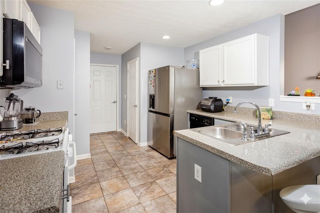 269 Silver Ridge Drive Dallas, GA 30157 - Photo 16 of 33 a kitchen with stainless steel appliances granite countertop a sink stove refrigerator and cabinets