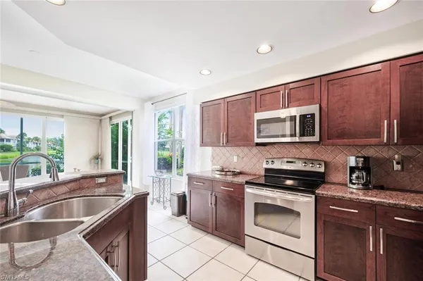 a kitchen with stainless steel appliances a stove sink microwave and cabinets
