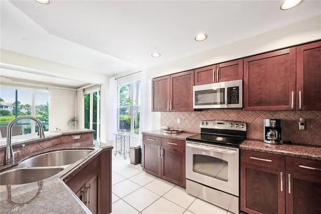 a kitchen with stainless steel appliances a stove sink microwave and cabinets