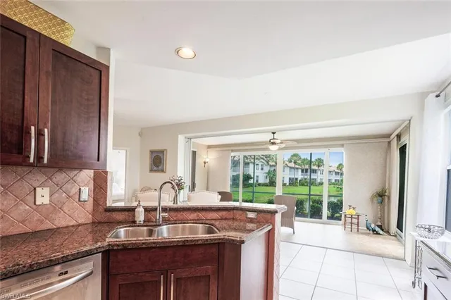 a view of a kitchen with kitchen island granite countertop a sink and a stove top oven