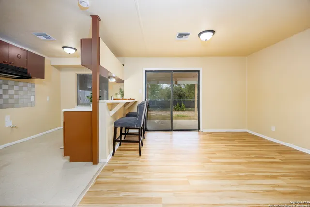 a view of a kitchen with furniture and wooden floor