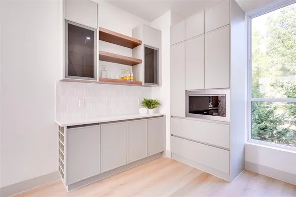 a large white kitchen with stainless steel appliances kitchen island granite countertop a stove and a sink