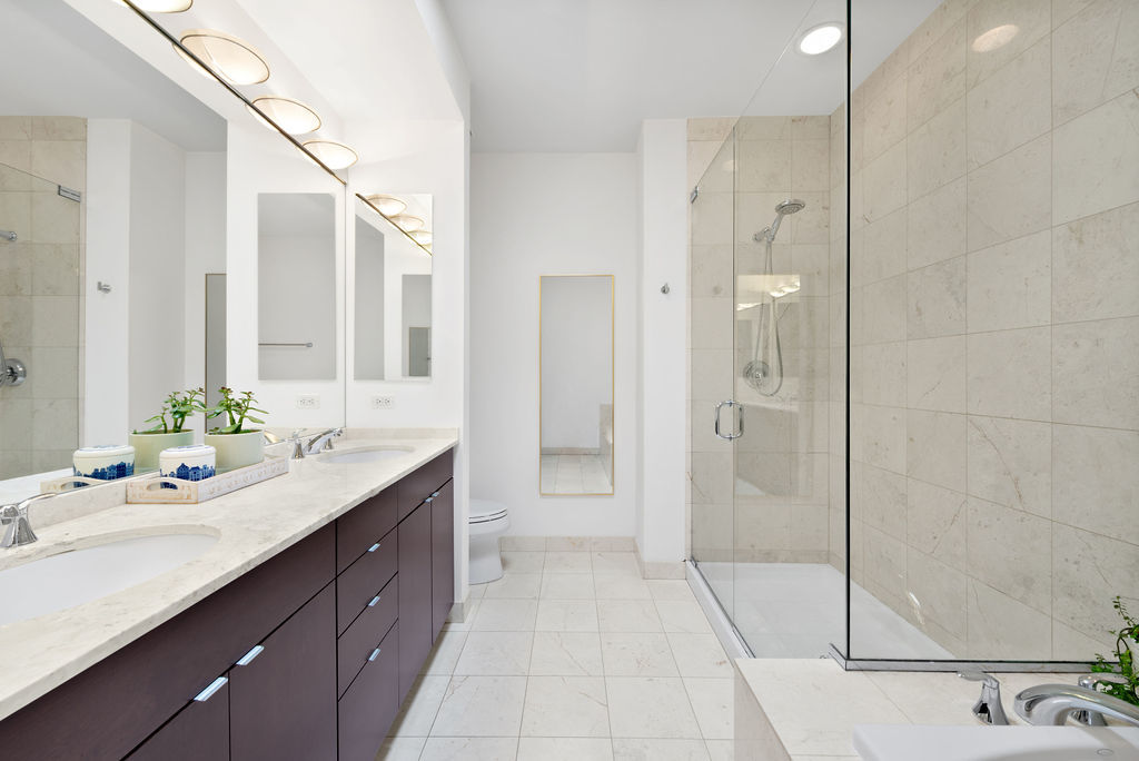 Undisclosed Address Chicago, IL 60607 - Photo 12 of 20 a spacious bathroom with a shower sink and mirror