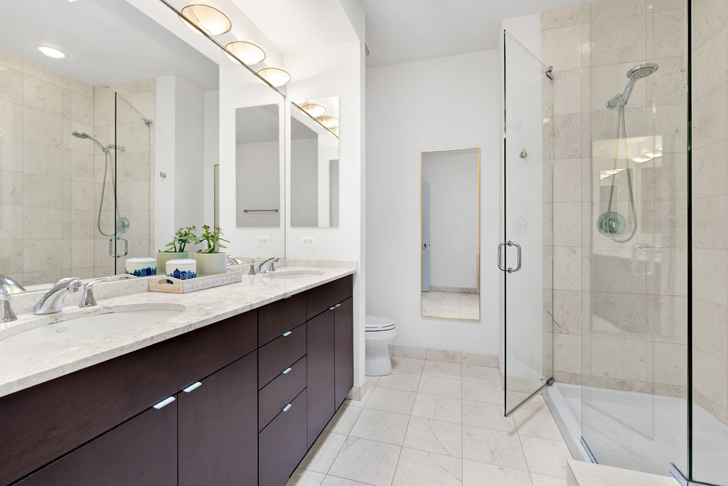 Undisclosed Address Chicago, IL 60607 - Photo 13 of 20 a bathroom with a shower sink and mirror