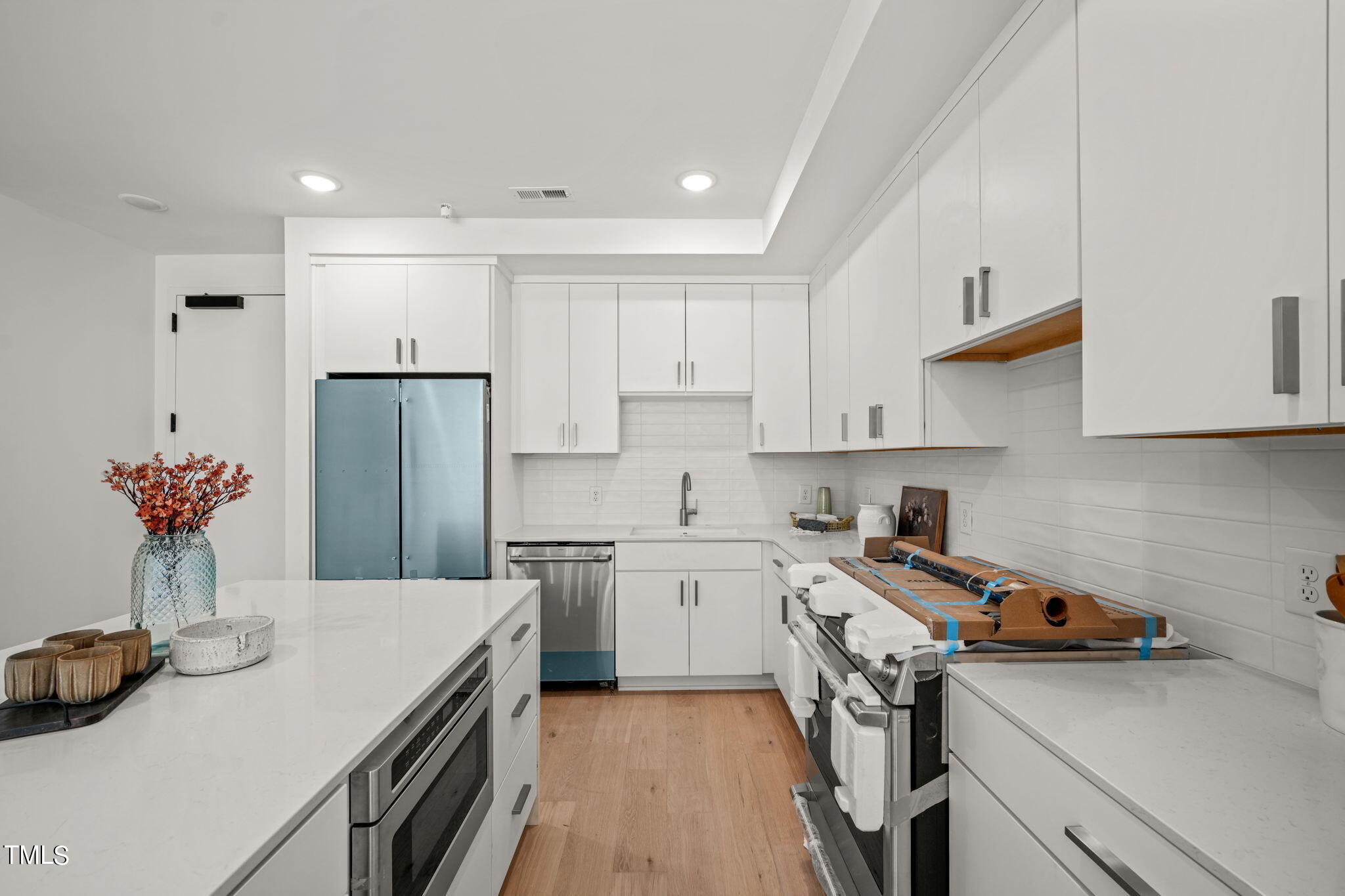 29 Enterprise Street, Unit 305 Raleigh, NC 27607 - Photo 6 of 48 a kitchen that has a sink a stove and a refrigerator