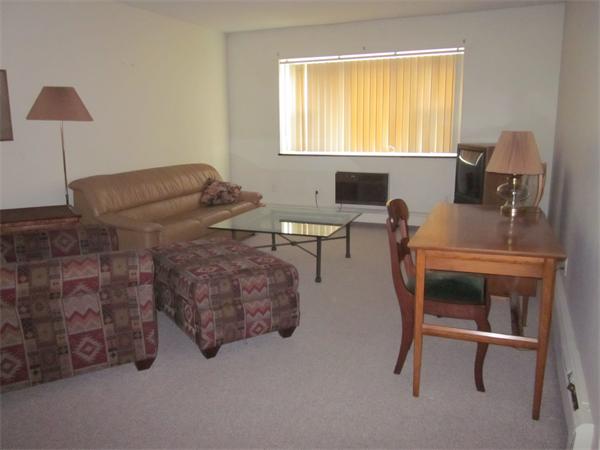 73 Walnut Street, Unit 6 Newton, MA 02460 - Photo 7 of 8 a bedroom with a bed and a chair