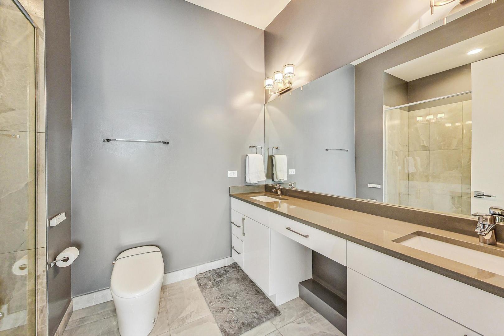 4042 North Pulaski Road, Unit 4E Chicago, IL 60641 - Photo 14 of 32 a spacious bathroom with a granite countertop sink a toilet and a mirror