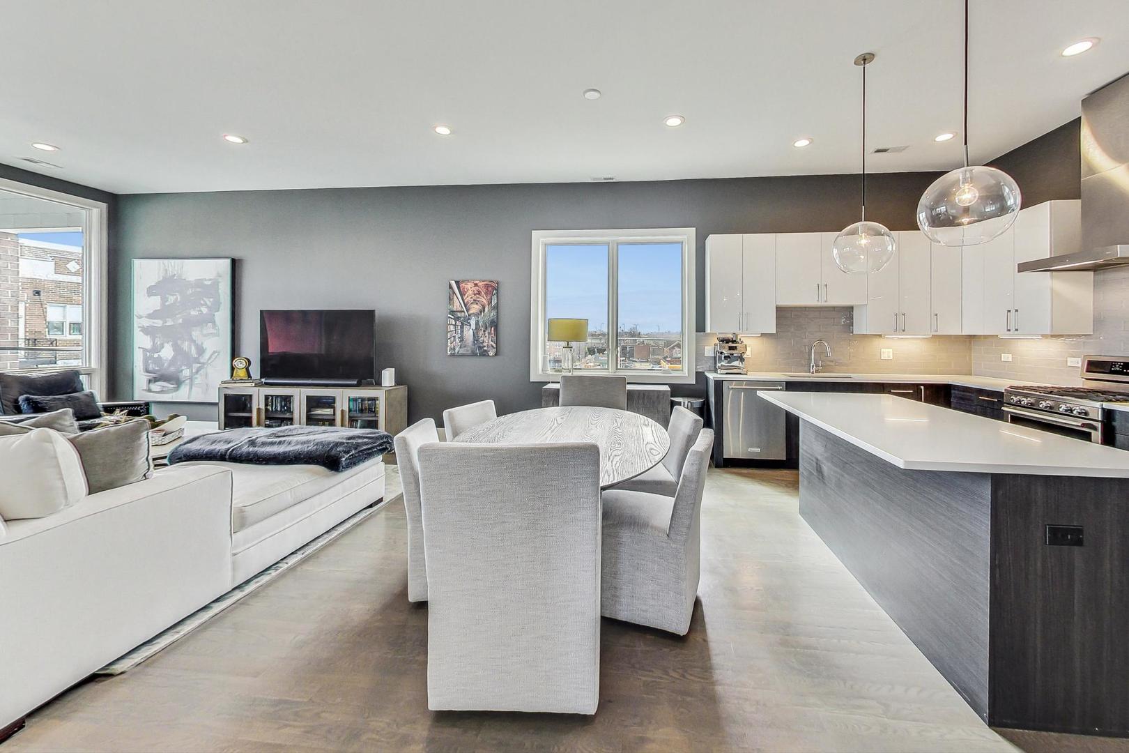 4042 North Pulaski Road, Unit 4E Chicago, IL 60641 - Photo 5 of 32 a large kitchen with kitchen island a large counter top space a sink stainless steel appliances and cabinets