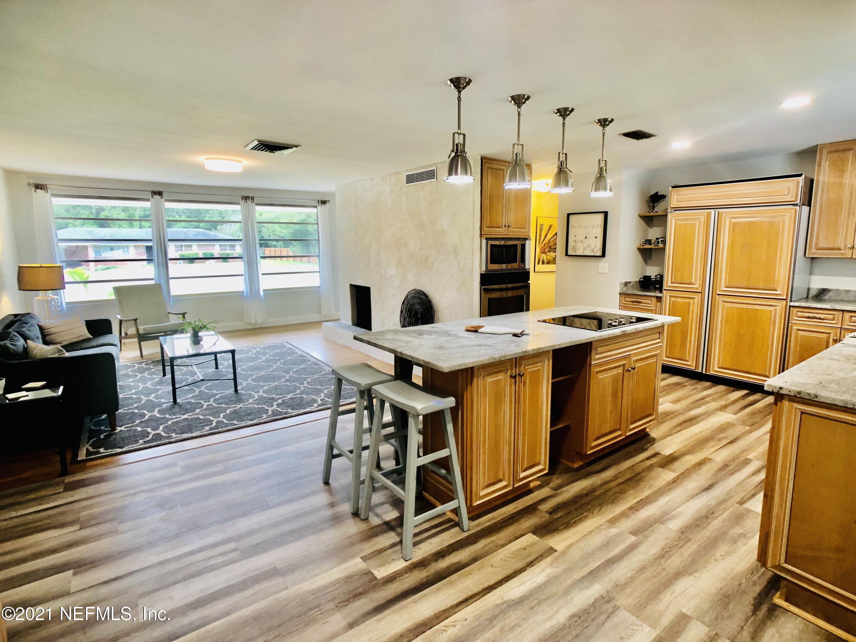 9831 Cunningham Road Jacksonville, FL 32246 - Photo 4 of 25 a view of a kitchen with a table chairs refrigerator and a stove top oven