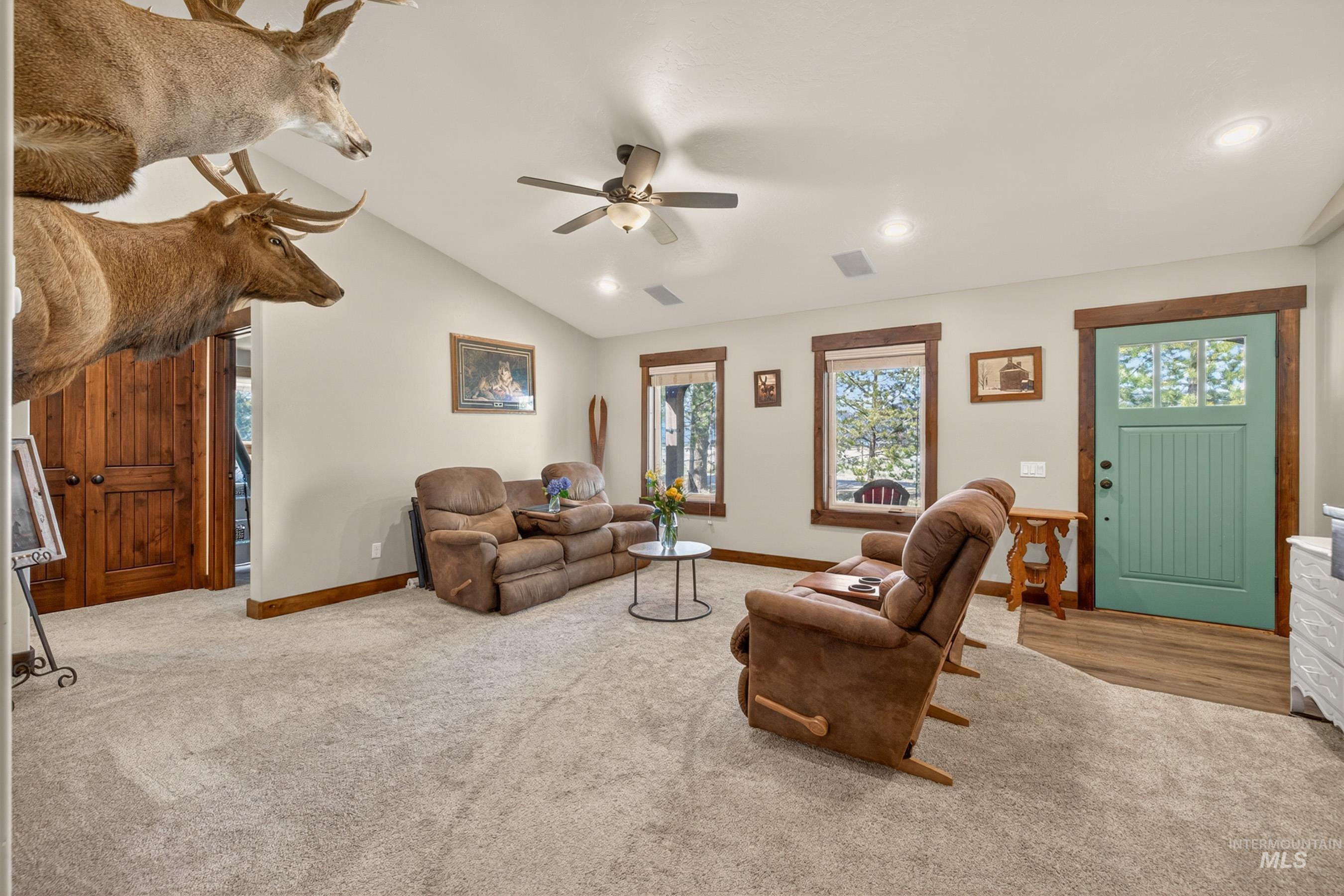 13388 Norwood Road McCall, ID 83638 - Photo 8 of 44 Living area featuring vaulted ceilings, recessed lighting, wood-finish flooring at entry, wood-trimmed windows, and a ceiling fan with light fixture