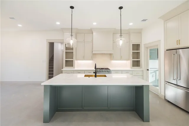 a kitchen with kitchen island white cabinets and stainless steel appliances