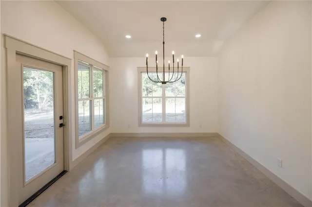 a view of an empty room with glass door and windows