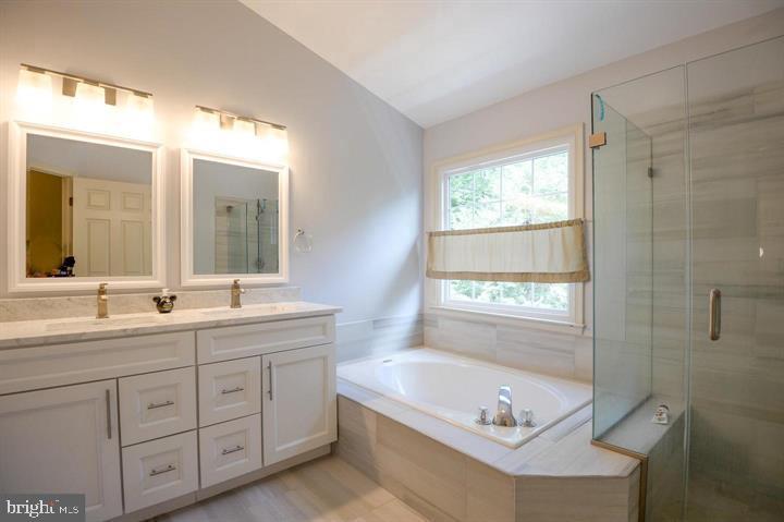 9404 Regency Crest Drive Vienna, VA 22181 - Photo 15 of 25 a bathroom with a tub a sink and mirror