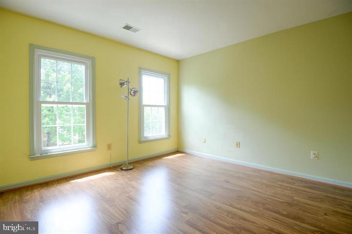 9404 Regency Crest Drive Vienna, VA 22181 - Photo 16 of 25 an empty room with wooden floor and windows
