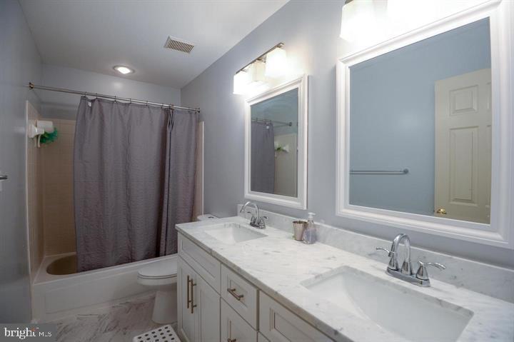 9404 Regency Crest Drive Vienna, VA 22181 - Photo 18 of 25 a bathroom with a granite countertop sink toilet and shower