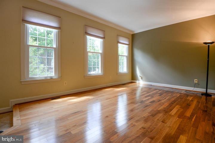 9404 Regency Crest Drive Vienna, VA 22181 - Photo 4 of 25 a view of an empty room with wooden floor and a window
