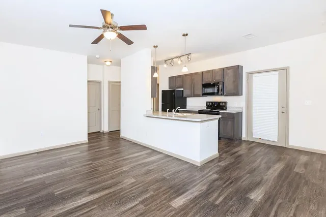 a view of kitchen with sink microwave and refrigerator